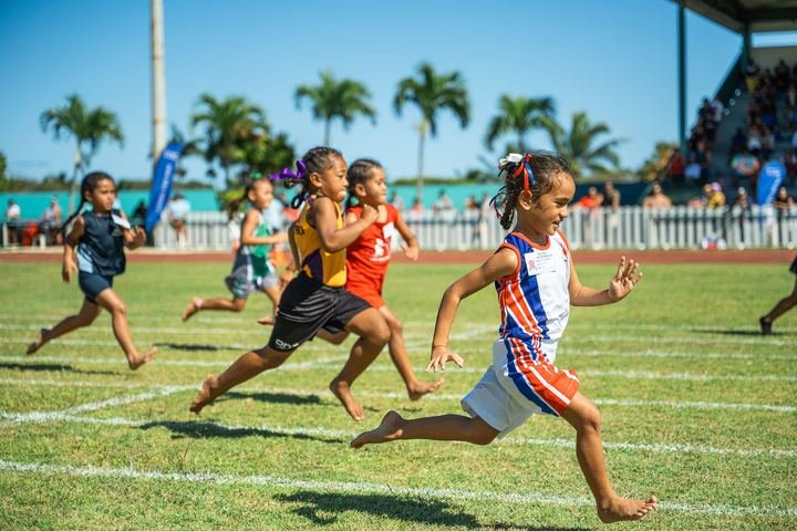 The youngest sprinters race flat out on the grass straight.