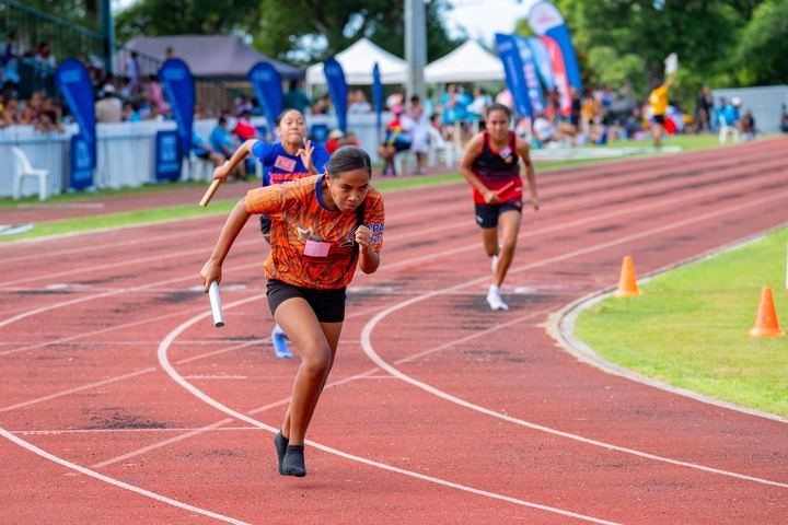 Baton in hand, a relay runner drives round the bend