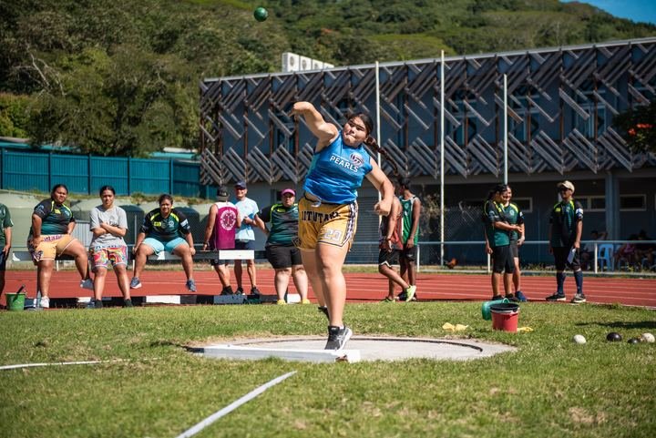 Shot put release with teammates watching