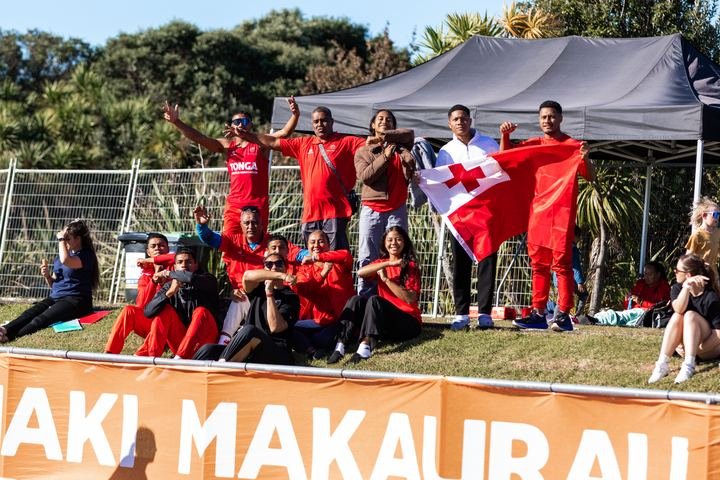 Supporters fly the Tongan flag trackside