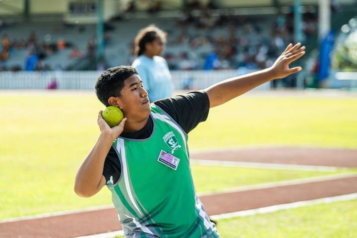 Shot put action in the throwing circle.