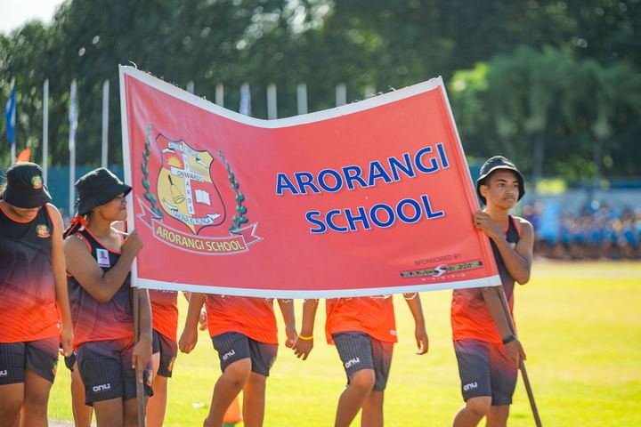 Arorangi School carry their banner in the march past.