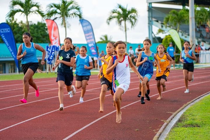 A big field of girls powers down the straight